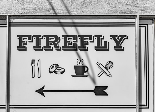 a street sign that reads firey with a arrow pointing to a cup of coffee