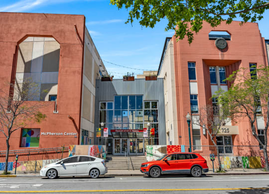 a street view of a building with two cars parked in front of it