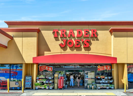 a trader joes store with a red sign on the front of it