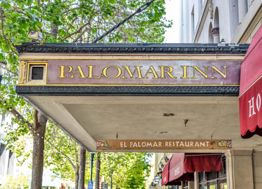 a sign for the palomar inn on the side of a building