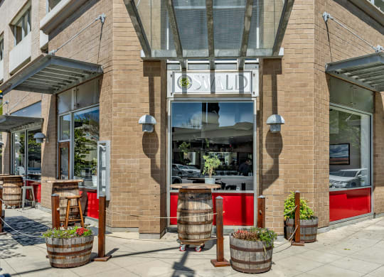 the front of a restaurant with barrels in front of it
