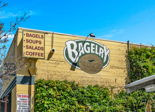a sign for a bagel shop on the side of a building