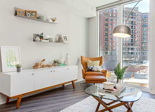 a living room with a large window and a glass coffee table