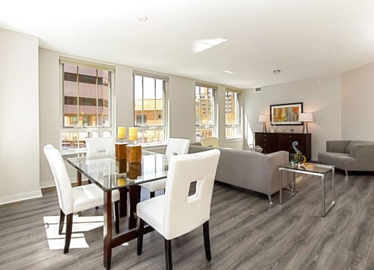 a living and dining room area with a glass table and white chairs