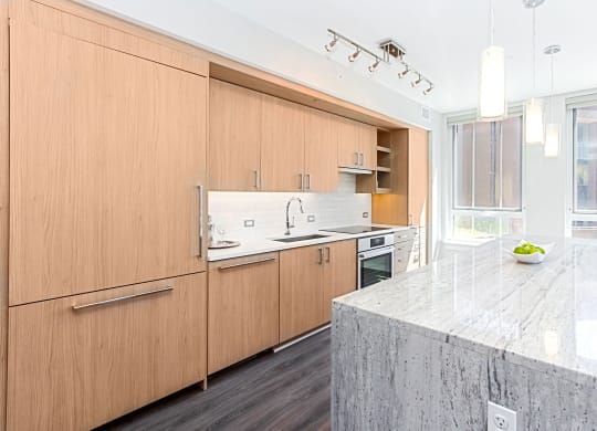 a kitchen with wooden cabinets and a marble counter top