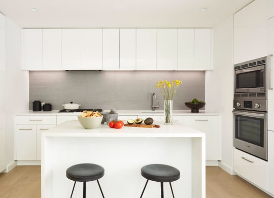 Kitchen showing island and all white cabinetry