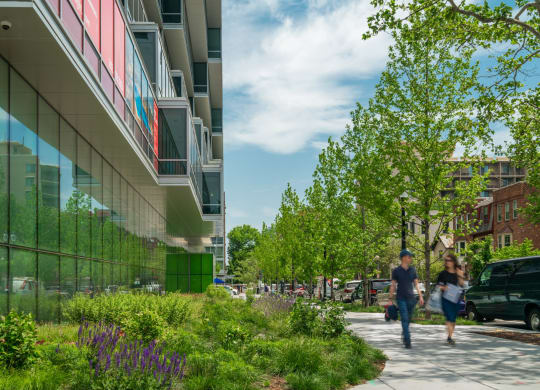 people walking down a sidewalk next to a building