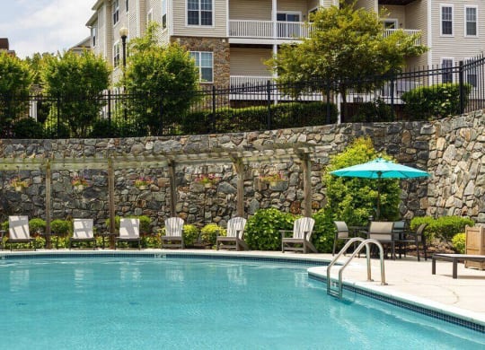 Sparkling Swimming Pool with lounge furniture and manicured landscaping with stone walls at Chesapeake Ridge, North East, Maryland