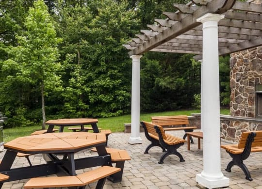 Stunning outdoor fireplace lounge with stone wall and pergola at Chesapeake Ridge, North East, MD, 21901