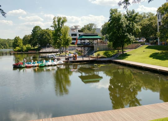A serene lake with a dock and a building in the distance.