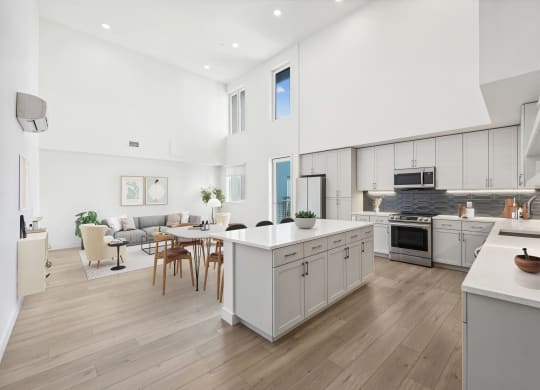 an open kitchen and living room with a table and chairs