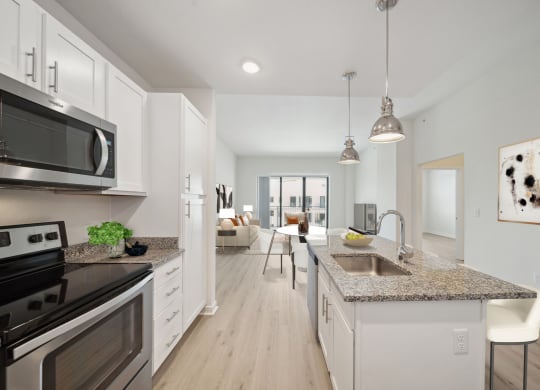 an open kitchen and living room with a sink and counter top