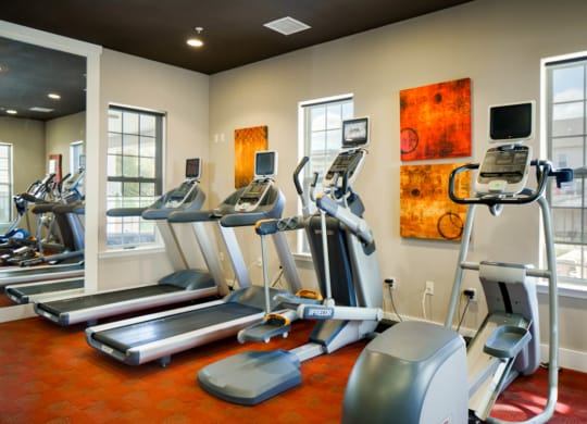 a gym with treadmills and other exercise equipment