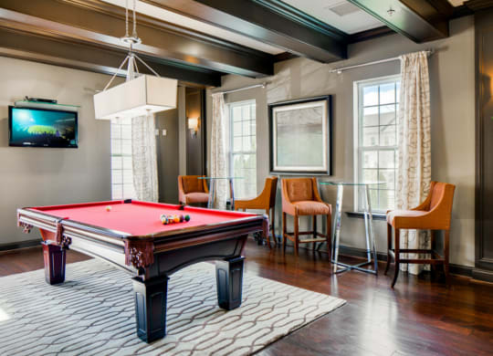 a game room with a pool table and a tv
