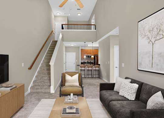 Virtually staged two-story living room at Enclave at Emerson with high ceilings, a staircase to an open loft, lounge seating and a kitchen with breakfast bar seating.