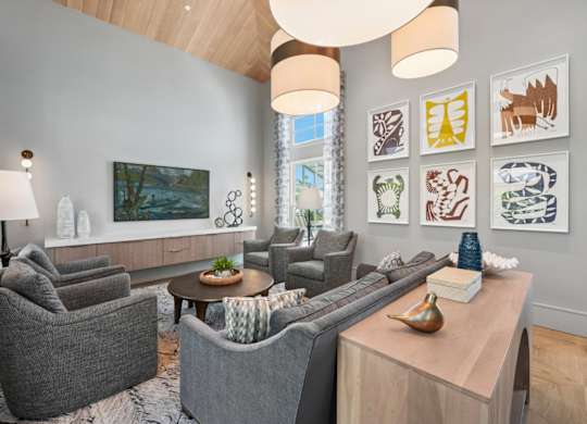 Resident clubroom at Marlin Cove Apartments with vaulted ceilings, modern seating, and contemporary coastal décor.