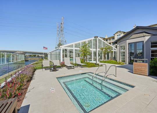 hot tub with waterfront views and outdoor seating