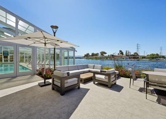 Pool deck lounge at Marlin Cove Apartments with waterfront seating and indoor pool access.