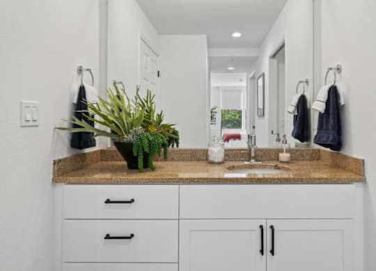 Bathroom vanity at Marlin Cove Apartments with granite countertops and modern cabinetry.