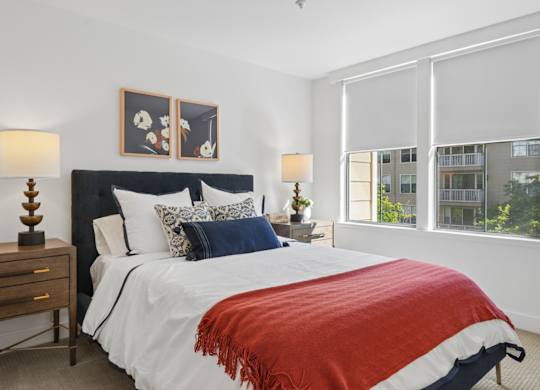 Bedroom at Marlin Cove Apartments with oversized windows, soft finishes, and contemporary furnishings.