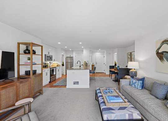 Open-concept living room and kitchen at Marlin Cove Apartments with contemporary furnishings and dining area