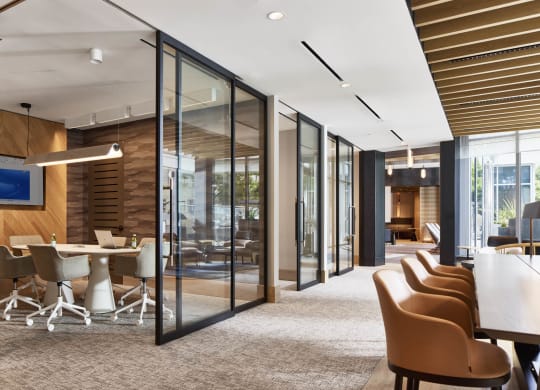 a conference room with glass walls and a table with chairs