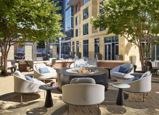 a patio with chairs and tables and a fire pit