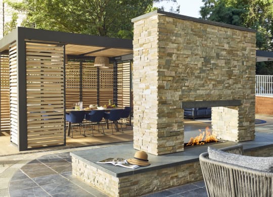 a stone fireplace and a dining area with a table and chairs