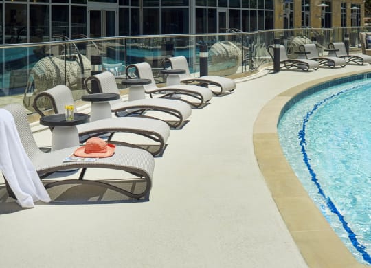 a row of lounge chairs next to a pool