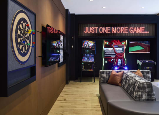 a room with a couch and a dart board and a game on the wall
