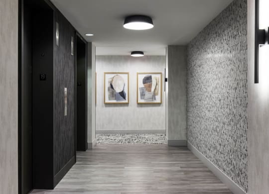 a hallway with two paintings on the wall and a door