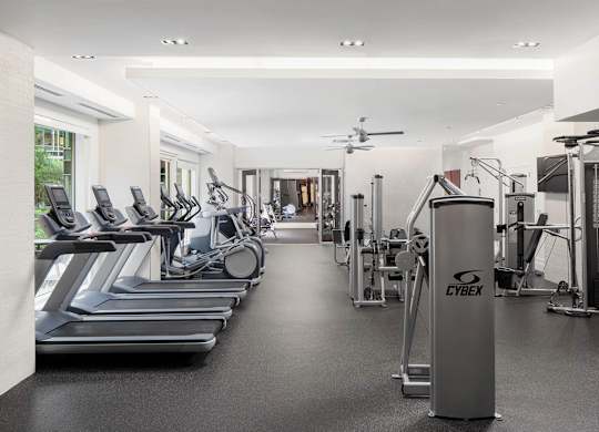 A gym with treadmills, weights, and exercise equipment.