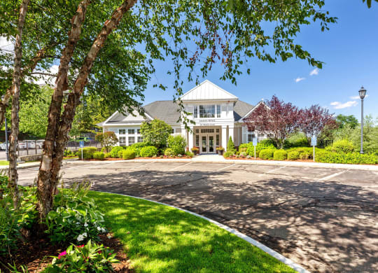 the front of a house with a driveway and trees