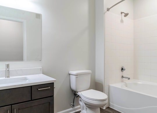 a bathroom with a toilet sink and tub and a mirror