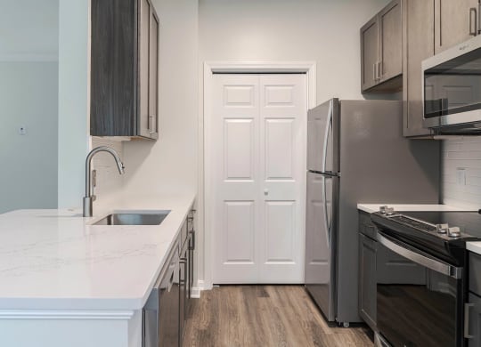 a kitchen with a sink and a refrigerator and a door