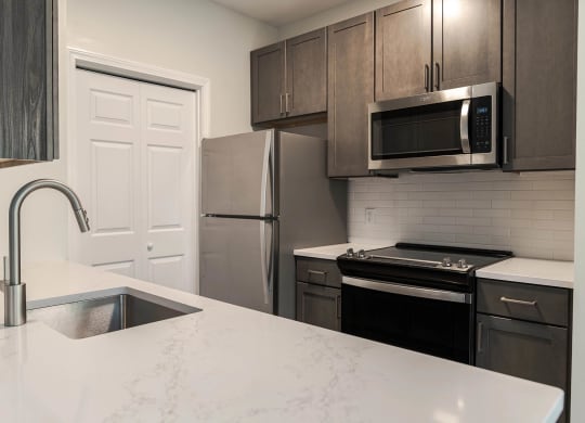 a kitchen with stainless steel appliances and a white counter top