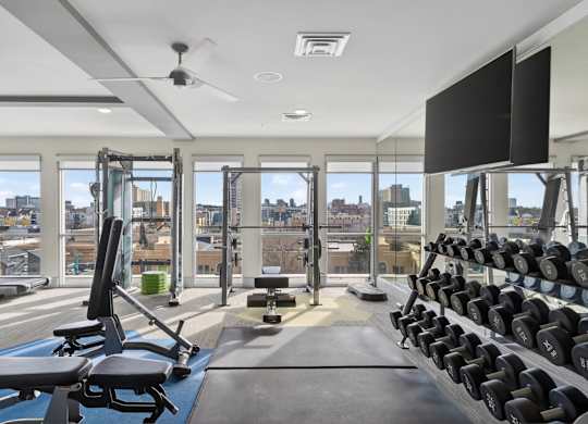 Bright apartment gym with exercise machines and sleek modern interior.