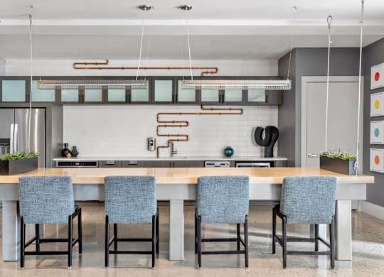 A modern kitchen with a long table and chairs.