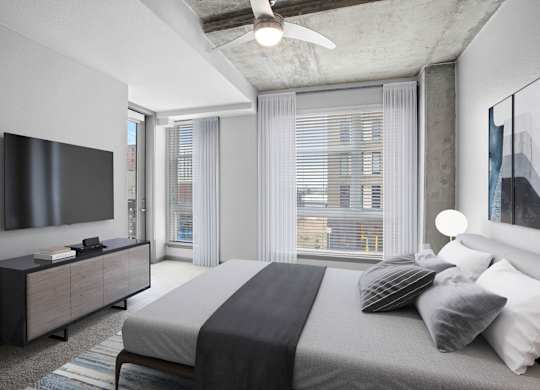 Contemporary apartment bedroom with large windows, neutral tones, and city views in Denver.
