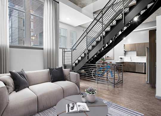Elegant living room with contemporary furniture and a staircase behind it.