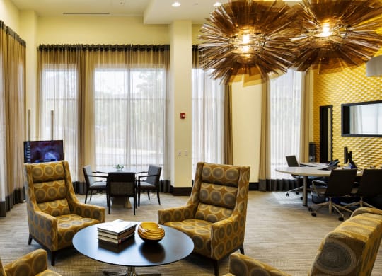 A business center with cushion chairs and round tables.