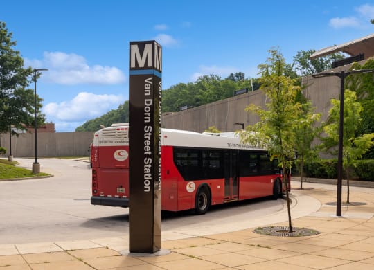 a red bus parked in front of a sign for the mg bus stop