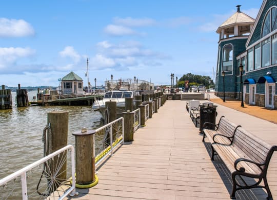 a dock with benches and boats in the water at a marina