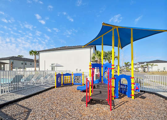 A playground with a blue canopy and yellow poles.