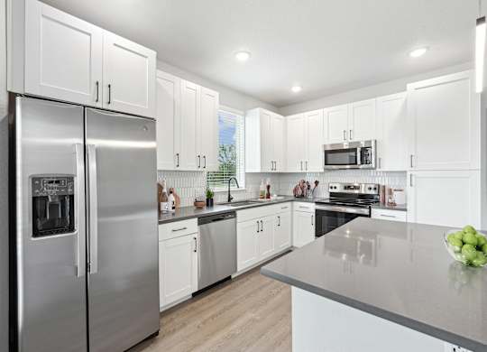 Model kitchen with stainless steel appliances and large kitchen island