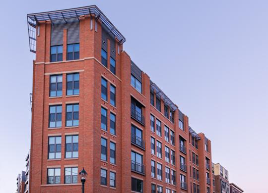 A tall red brick building with a black lamp post in front.