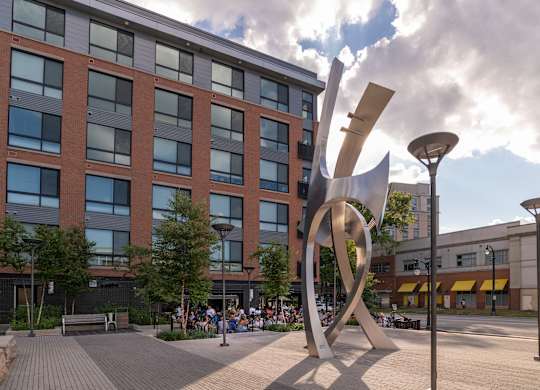 A large metal sculpture in front of a brick building.
