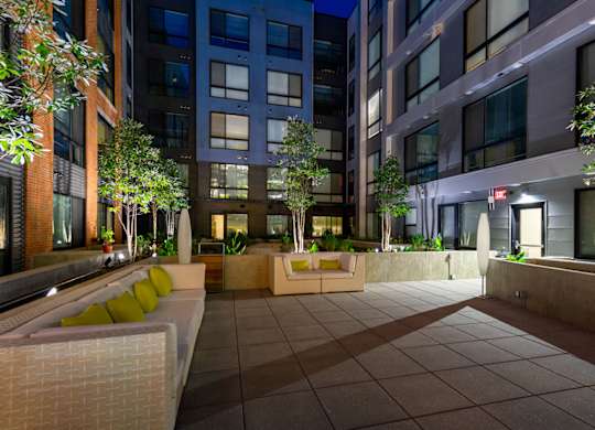 A courtyard with a bench and a tree.