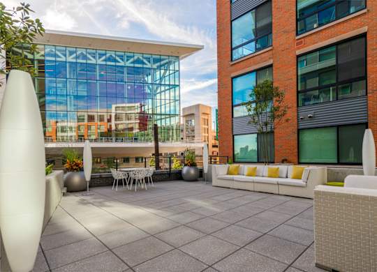 A modern outdoor seating area with white furniture and a large white sculpture.