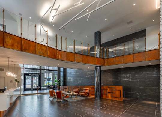 A modern interior with a black floor and a white reception desk.